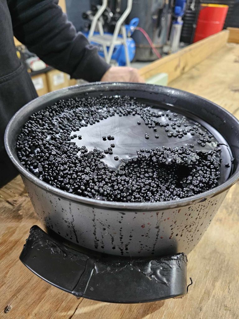 Black wax starting to melt for dipping of the bottles